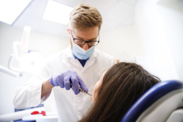 A dentist performs surgery on a patient