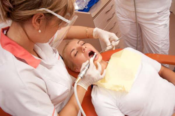 A woman does dental surgery on another woman